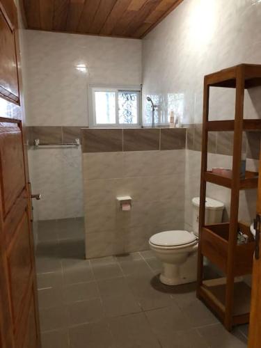 een badkamer met toilet en een glazen douche bij Villa Dave Kribi in Kribi