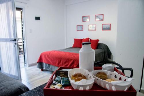 a tray with food and a bottle of milk and a bed at Apart Valeria cerca del Mar in Valeria del Mar