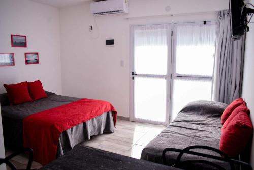 a bedroom with two beds and a sliding glass door at Apart Valeria cerca del Mar in Valeria del Mar