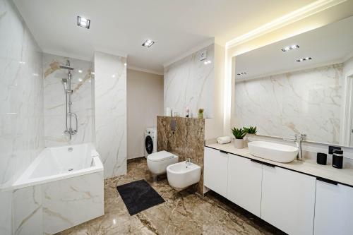 a bathroom with a tub and a sink and a toilet at Luxury Oasis Flat in Chişinău
