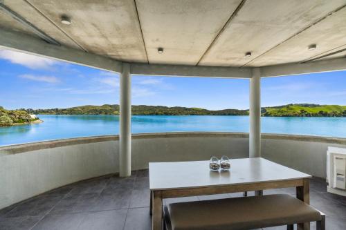 a room with a table and a view of the water at The Silos Apartments in Raglan