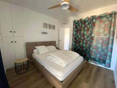 une chambre avec un lit et un ventilateur de plafond dans l'établissement EDEN CATALAN 5 personnes meublé tourisme 