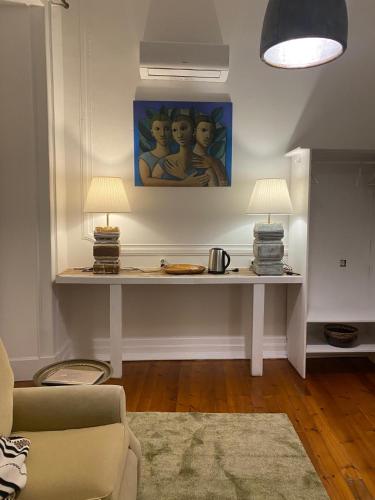 a living room with a table with two lamps on it at Casarão AL in Olhão