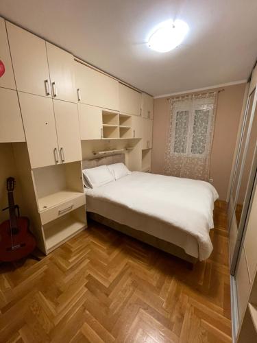 a small bedroom with a bed and a guitar at AP Apartment in Kotor