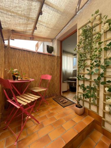 une chambre avec des chaises rouges, une table et une plante dans l'établissement Rayon de soleil, à Palavas-les-Flots
