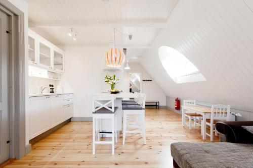 a kitchen and dining room with white cabinets and a table at Ösel Apartment in Kuressaare