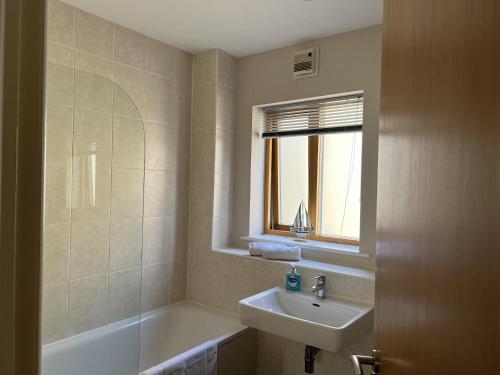 a bathroom with a sink and a bath tub at Cozy City Escape in Norwich in Norwich