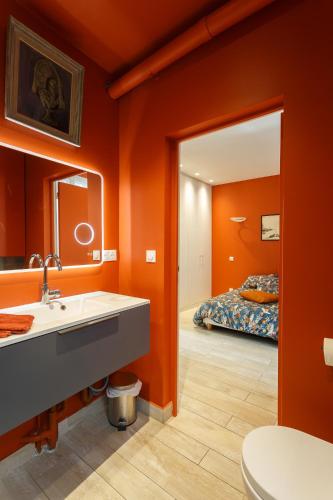 une salle de bain avec un lavabo, un miroir et un lit dans l'établissement Stade de France & 15min de Montmartre, à Saint-Denis