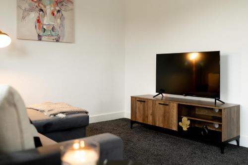 a living room with a flat screen tv and a couch at Modern 2-Bed Apartment with Balcony, Close To Oxford City Centre With Free Parking in Oxford