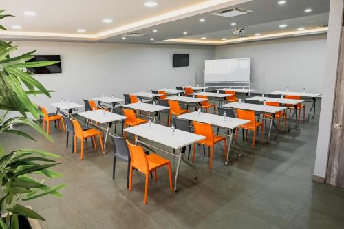 an empty classroom with tables and orange chairs at Life Hotel in Oaxaca City