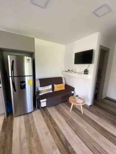 a living room with a couch and a refrigerator at Rent Suite Jama Manabí Deluxe in Jama