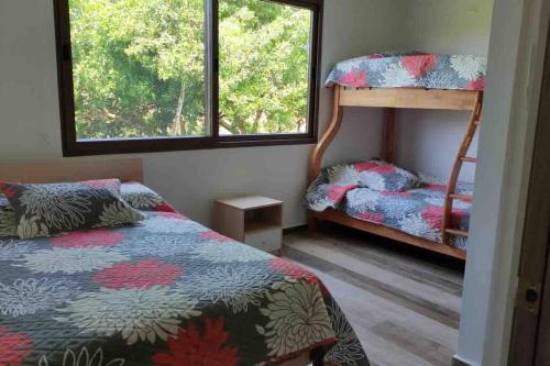 a bedroom with two bunk beds and a window at Rent Suite Jama Manabí Deluxe in Jama