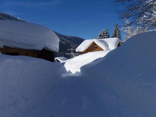 a pile of snow next to a house at Landhaus Luzia in Wald am Arlberg
