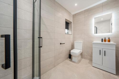 a bathroom with a toilet and a glass shower at The Boot Rooms Anfield in Liverpool