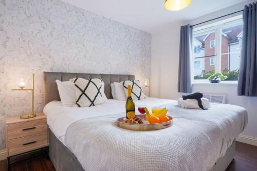 a bedroom with a bed with a bottle of wine on it at Beautiful Apartment - Close to City Centre - Free Parking, Fast Wifi, SmartTV with Sky TV and Netflix by Yoko Property in Northampton