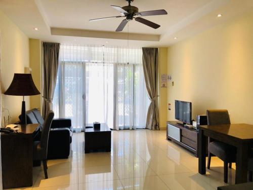 a living room with a ceiling fan and a television at Palm Beach Hotel Dili in Dili