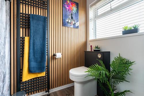 a bathroom with a toilet and a blue towel at Triumph House in Hinckley