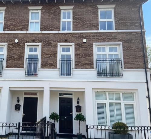 a large brick building with black doors and windows at Beautiful town house in the heart of Knutsford in Knutsford