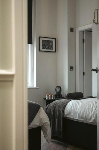 a bedroom with a bed and a table and a window at The Boot Rooms Anfield in Liverpool