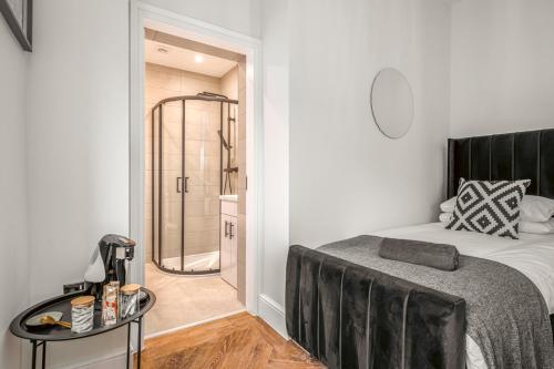 a bedroom with a bed and a walk in shower at The Boot Rooms Anfield in Liverpool