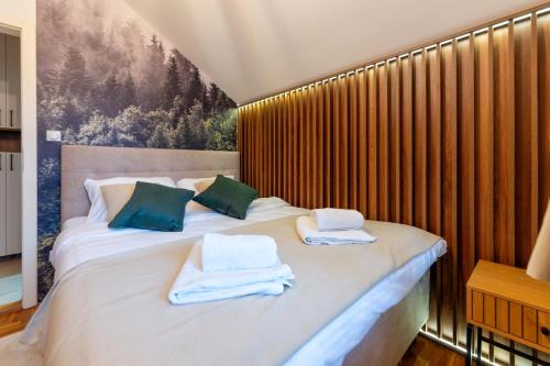 a bedroom with a bed with towels on it at Apartman Vuk Zlatibor in Zlatibor