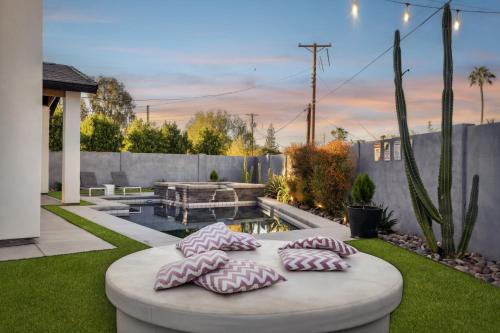 a patio with cushioned pillows on a circular table in a yard at Modern Industrial-Near Old Town in Scottsdale