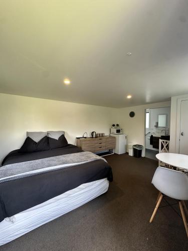 a bedroom with a large bed and a table at Green Valley Cabin in Hamilton