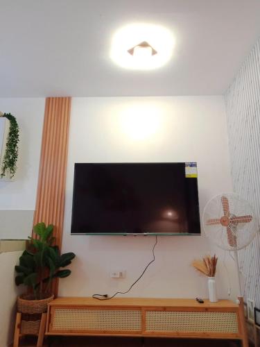 a flat screen tv hanging on a wall at Bali inspired 2 bedroom in Lipa netflix pool and parking in Muntingpulo