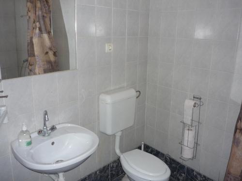 a bathroom with a white toilet and a sink at Jáde Panzió in Budapest