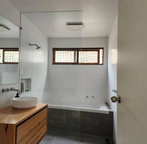 a bathroom with a sink and a bath tub at Family beach house among the gum trees in Ocean Grove