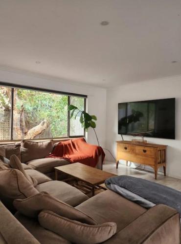 a living room with a couch and a table at Family beach house among the gum trees in Ocean Grove