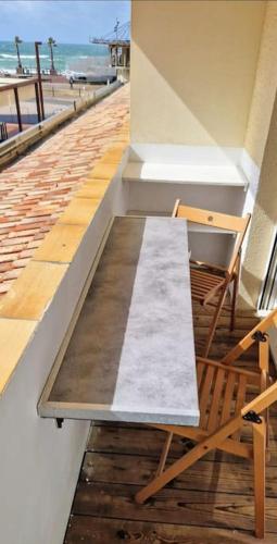 un banc assis sur le côté d'un bâtiment dans l'établissement Appartement à 20 m de la plage, à Lacanau