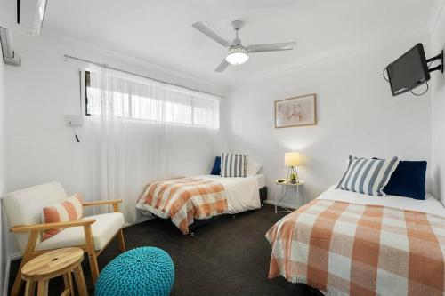 a bedroom with two beds and a chair at Sapphire by the Sea - Beach Family Modern in Grange