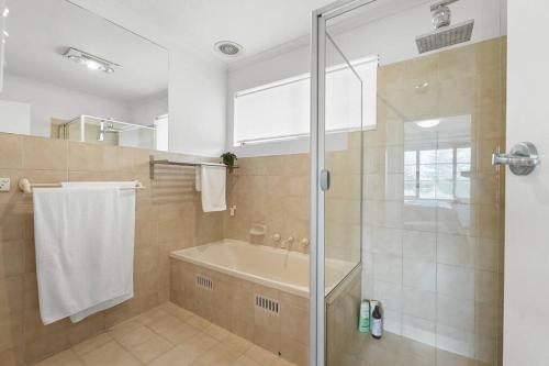 a bathroom with a shower and a tub and a sink at Sapphire by the Sea - Beach Family Modern in Grange