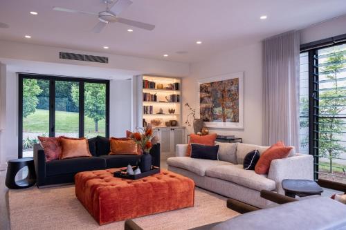 a living room with two couches and an orange rug at Serendipity, Kangaroo Valley in Barrengarry