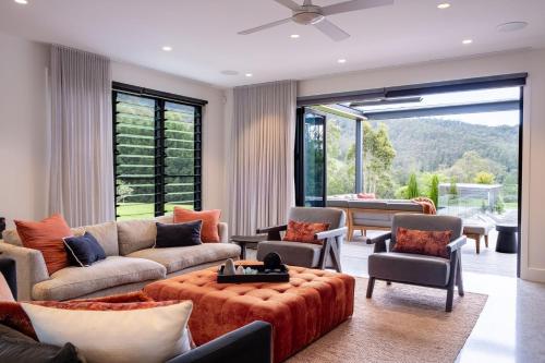 a living room filled with furniture and a large window at Serendipity, Kangaroo Valley in Barrengarry