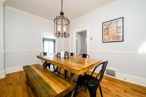 a dining room with a wooden table and a chandelier at Elm St Retreat - 3 Min walk to Downtown Three Oaks in Three Oaks