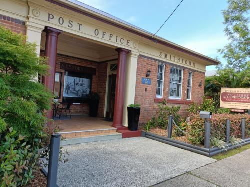 an old brick building with a post office on it at Post Office Boutique Accommodation in Hat Head