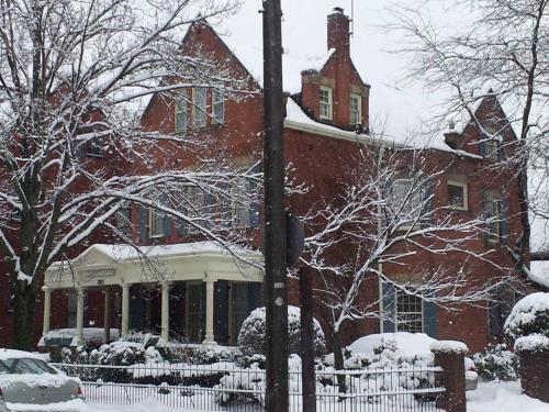 a large red brick building with snow on it at Clifford House Private Home B&B in Cleveland