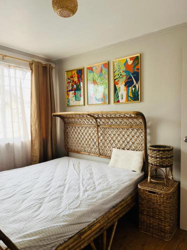 a bed in a bedroom with paintings on the wall at Casa Lamarah in San Pablo