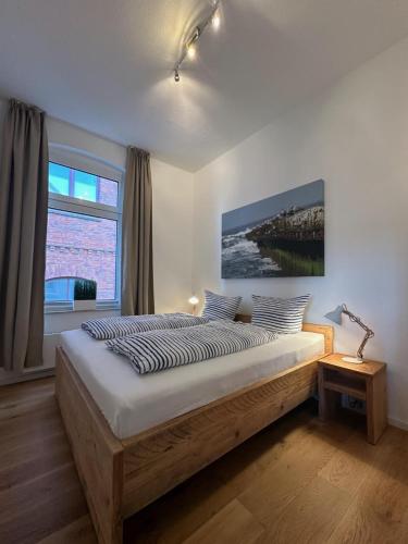a bedroom with a large wooden bed with a large window at Georg6 GEORG6 - Fewo 3 in Norderney