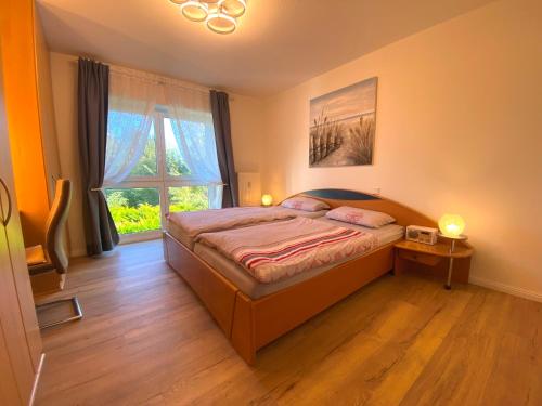 a bedroom with a bed and a window at Frische Brise in Schönberger Strand