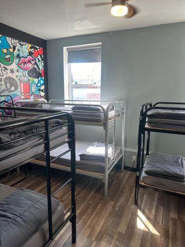 a room with three bunk beds and a window at Queen Nest Hotel in Toronto