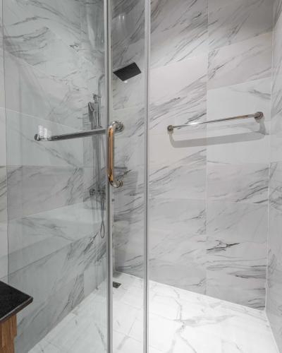 a shower with a glass door in a bathroom at George Residence Cooper Road, Ikoyi in Lagos