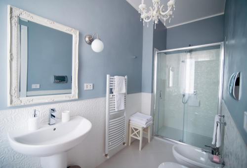B&B Home Sweet Home Rosolini في روسوليني: حمام أزرق مع حوض ودش