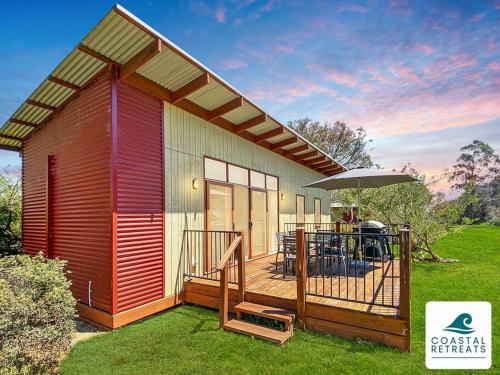 a small house with a deck and an umbrella at Moya's Villa - Phillip Island Cowes Resort Escape in Cowes