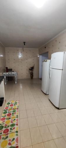 a kitchen with two refrigerators and a rug on the floor at Flor de Jabuticabeira in Jaguariúna