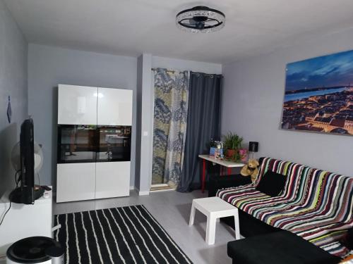 a living room with a couch and a tv at Ocean view 2 bedroom flat in Setúbal