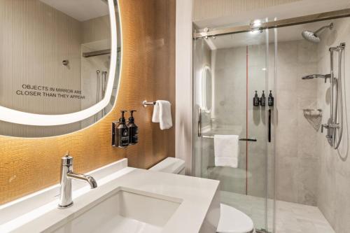 a bathroom with a sink and a shower at Hotel Indigo Baton Rouge Downtown by IHG in Baton Rouge