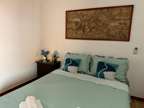 a bedroom with a bed with a painting on the wall at Pousada Casa de Buzios in Búzios